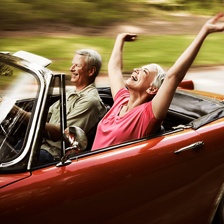 couple driving in convertible car