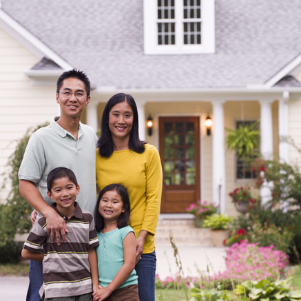 family standing in front of new home