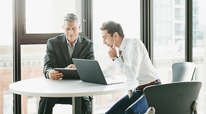 two men looking at laptop